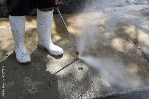 Power washing a dirty sidewalk