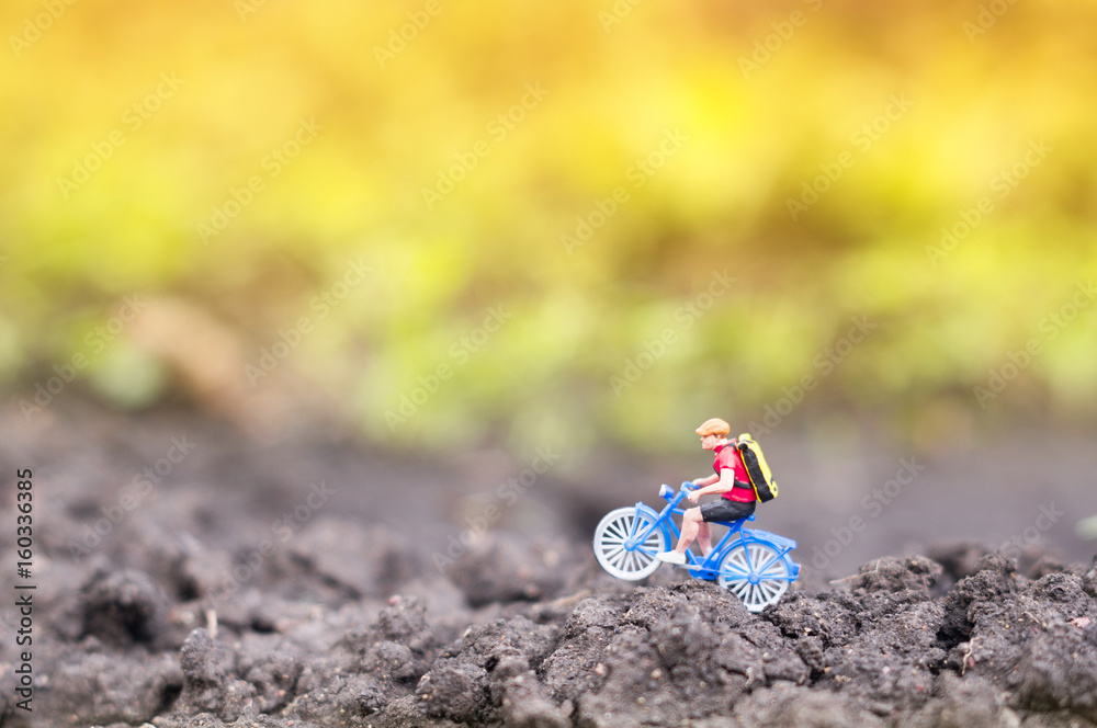 A toy cyclist is taking a ride in the sunset or the sunrise. Ecotourism concept. A toy cyclist is taking a ride in the sunset or the sunrise. Ecotourism concept.