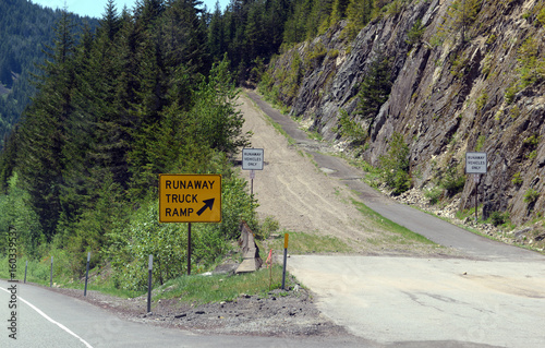 Road sign for Runaway truck ramp in the forest on a mountain road, designed to slow down a vehicle and help prevent accidents if a commercial truck loses braking or loses control down a steep hill.