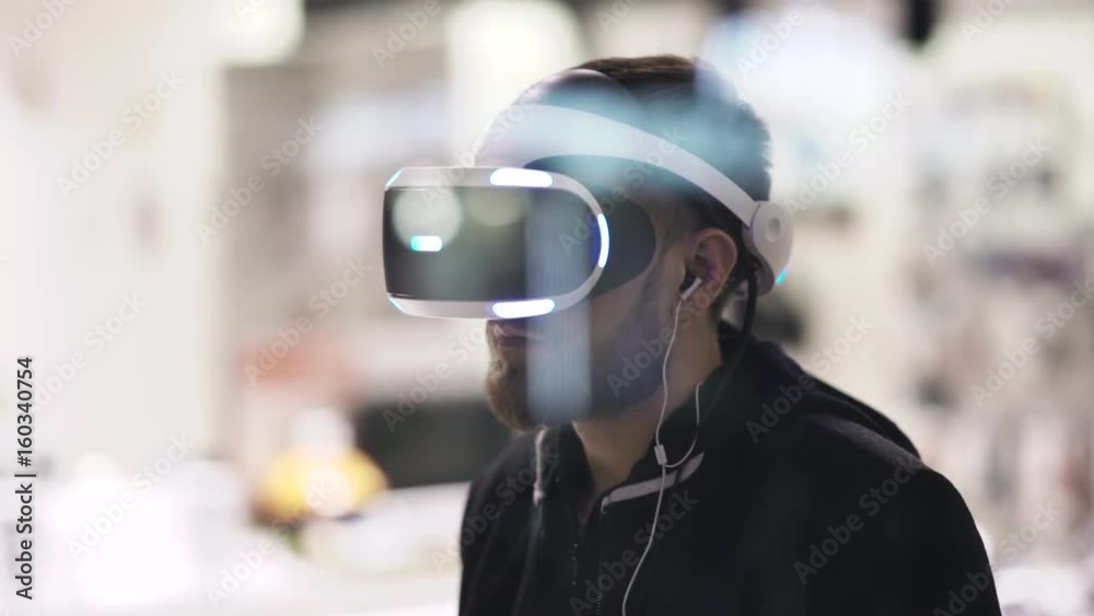 Bearded man uses VR-headset display with headphones for virtual reality game. UHD 4K Bearded man uses VR-headset display with headphones for virtual reality game. UHD 4K