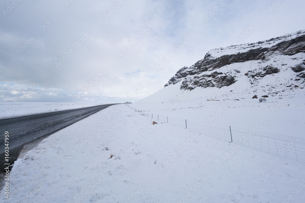Snow covered landscape and road, diminishing perspective by day, Iceland, Europe.