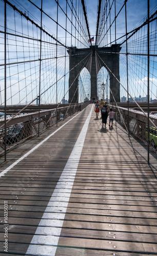 View along Brooklyn bridge with pedestrians walking, New York, USA.