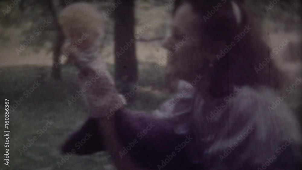 Little boy photographing his mother, mom posing with hand puppet. Screenshot of 8mm retro camera. Family chronicle.