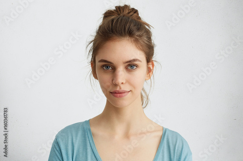 Fotografia Portrait of fair-haired woman with warm blue eyes, dry lips and healthy skin looking directly into camera
