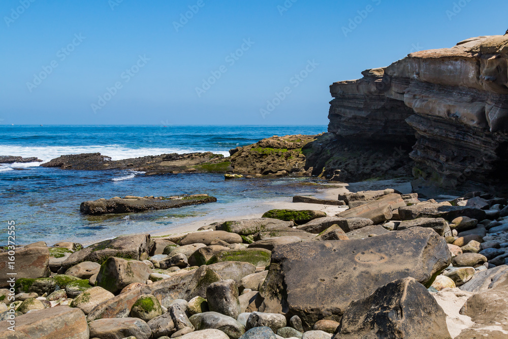The sandstone cliffs and scattered rocks and boulders at La Jolla Cove in San Diego County.  