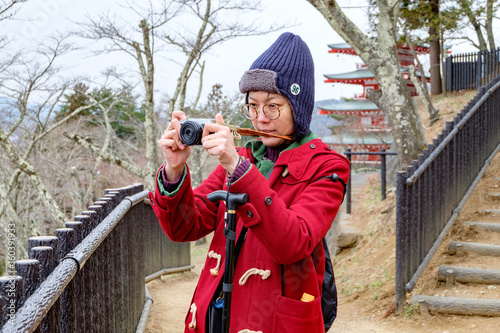 Women in red coat taking a photo at japan garden