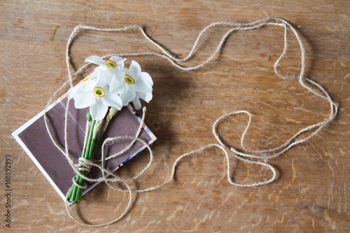 Fototapeta Naklejka Na Ścianę i Meble -  White daffodils bouquet on wooden background. Narcissus flowers and notebook. Romantic gift.