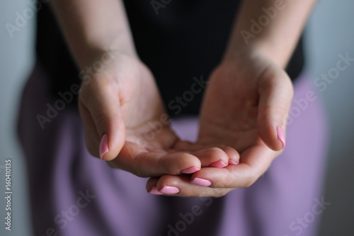 Young woman's hands keeps something. Gesture