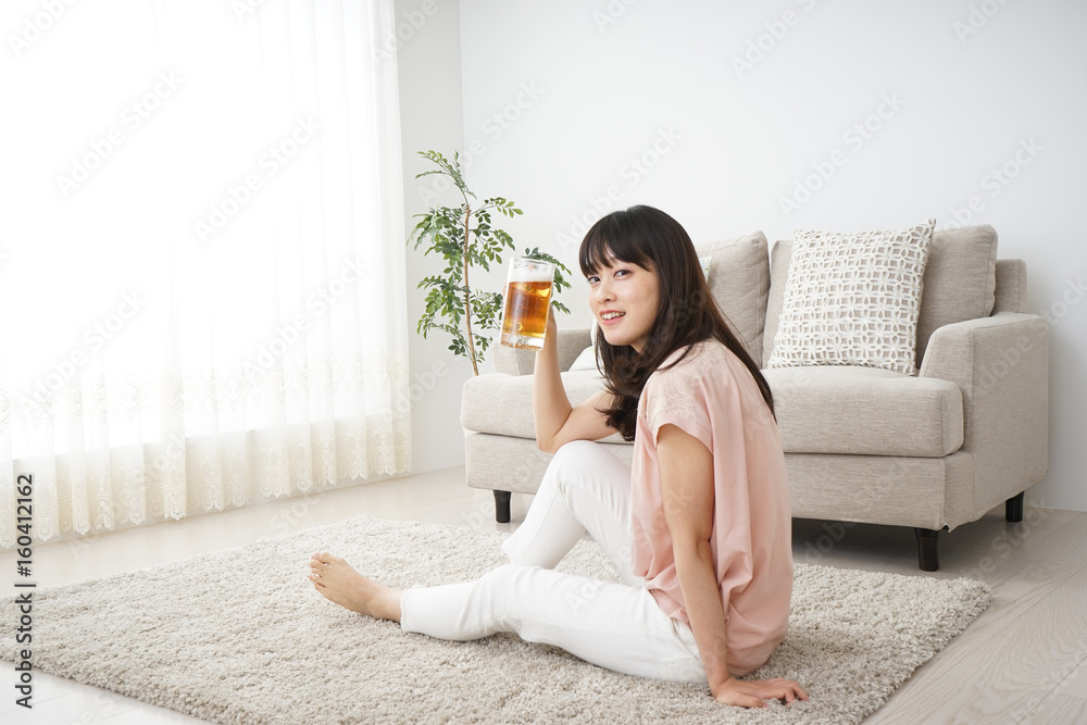 Young woman drinking beer at home Young woman drinking beer at home