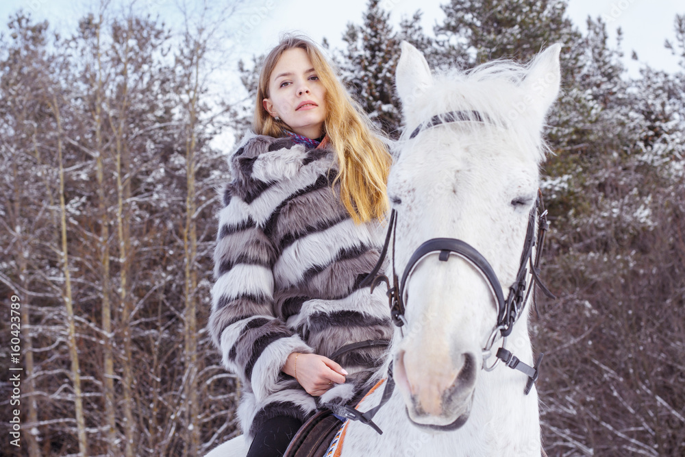 Fototapeta premium Nice girl and white horse in a forest in a winter
