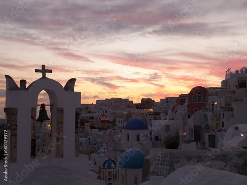 The church bell-tower against pastel color evening sky at Oia village, Santorini Island, Greece