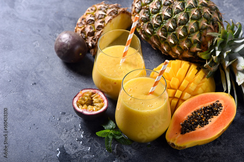Healthy smoothie with tropical fruits, pineapple, papaya and passion fruit, exotic vitamin drink