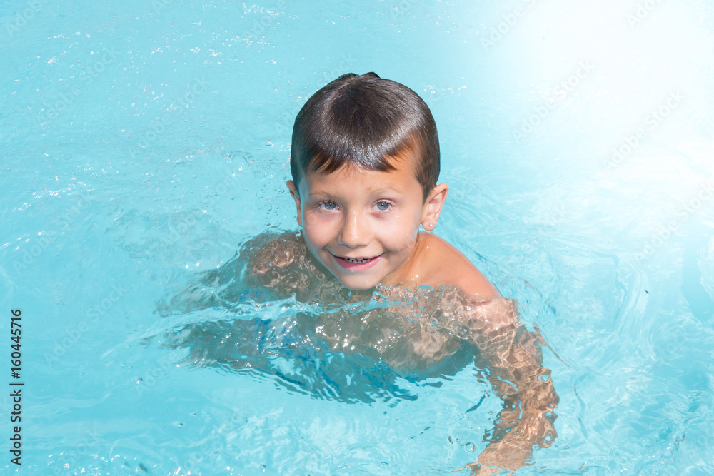 cheerful kid boy in pool in home