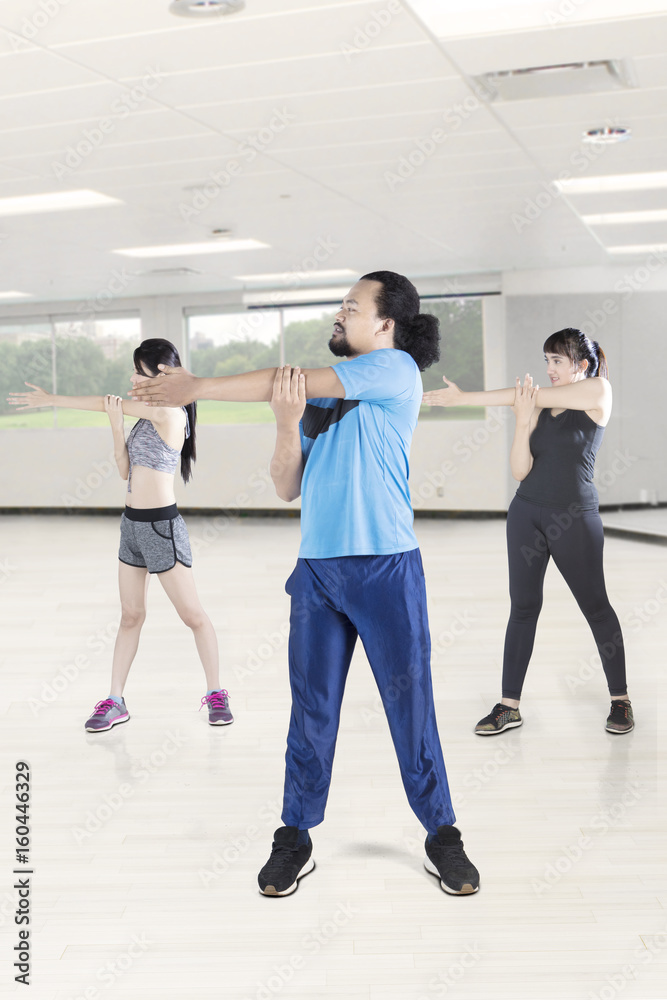 Fototapeta premium Young people doing stretching before exercise