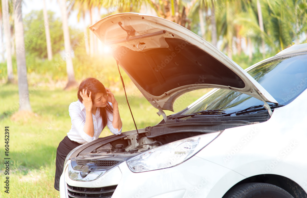 Naklejka premium Sad business women with a broken car with open hood