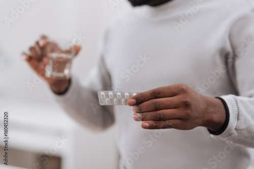 Selective focus of medicine being in hands of a nice adult man