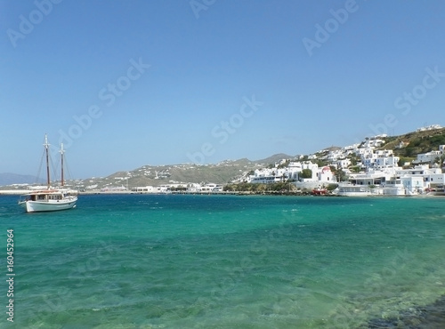 White fishing boat and little town between blue sky and blue sea, Mykonos Island, Greece © jobi_pro