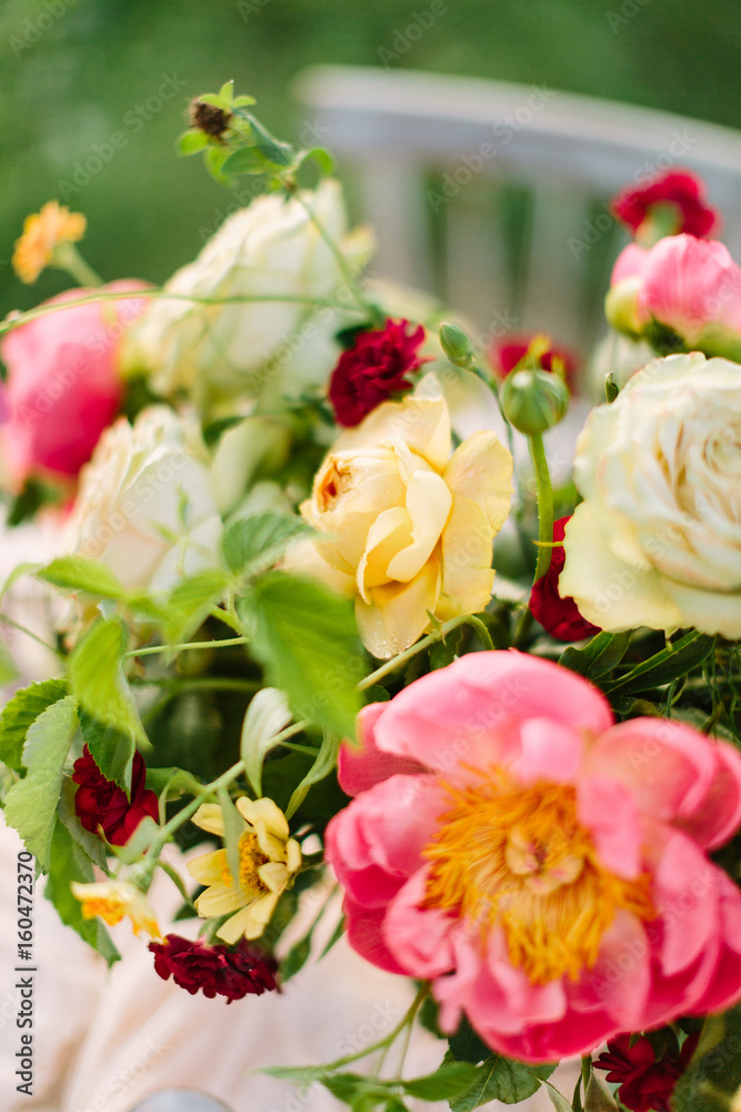 wedding decoration, floral design, gardening, holidays concept - colorful bunch of various flowers: tender pink peonies, creamy roses, bright carnations, and leaves of raspberry-bush