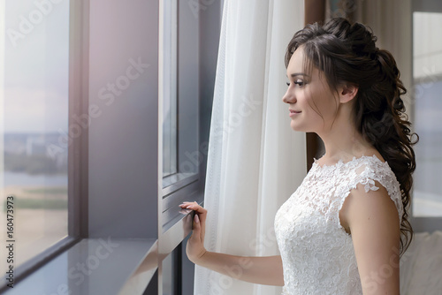 Beautiful bride looking out the window