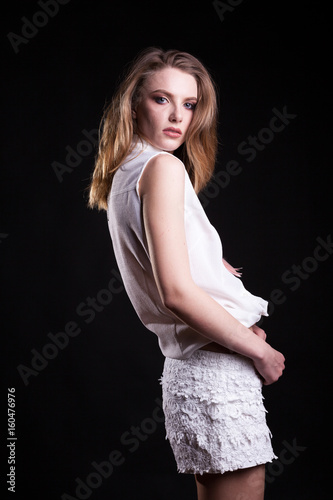 Sexy model in white shirts posing in fashion style on black background in studio photo. Sexyality and sensuality