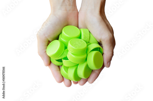 hand holding green plastic bottle cap on white background