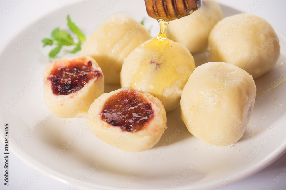 Close up of sweet plum dough dumplings in white plate Close up of sweet plum dough dumplings in white plate