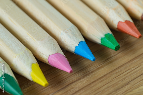 Selective focus on blue color of color pencils pile on wood table as art or education concept