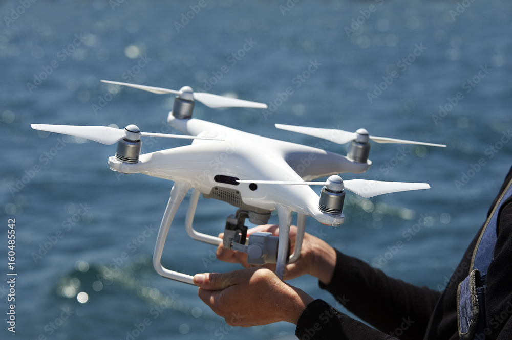 drone in hands with sea Photos | Adobe Stock