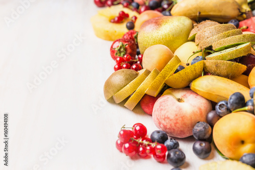 Summer fruits and berries on white table background. Healthy food and vegetarian eating concept