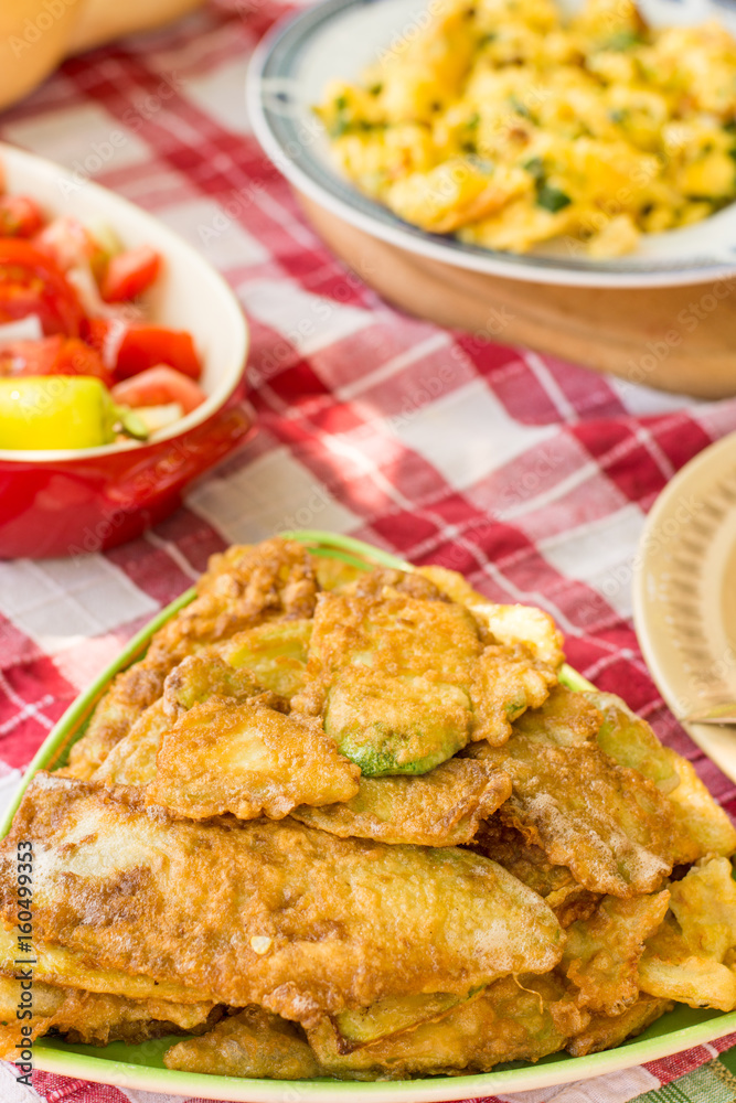 Served lunch with tomato salad and fried zucchini Served lunch with tomato salad and fried zucchini