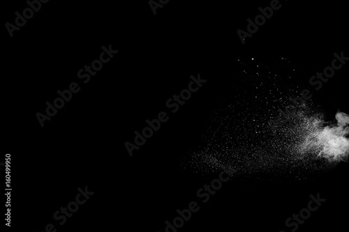 Powder explosion. Closeup of white particle explosion isolated on black background