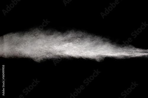 Powder explosion. Closeup of white particle explosion isolated on black background