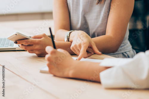 A business woman is reviewing the annual report, pointing on paper.