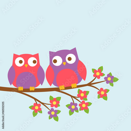 Couple of cute owls on blooming branch