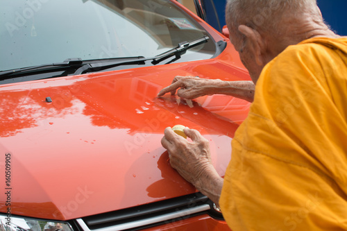 Fotografie Phatthalung,Thailand May 07 ,2017 : Unidentified monk anoints holy powder on a new car (Orange Ford ecosport) for the owner's lucky and safety, the transfer ceremony of new car