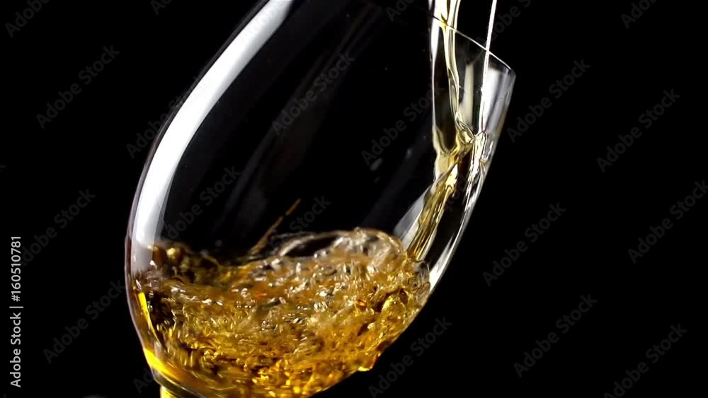 White wine  pouring into glass in slow motion 200 fps