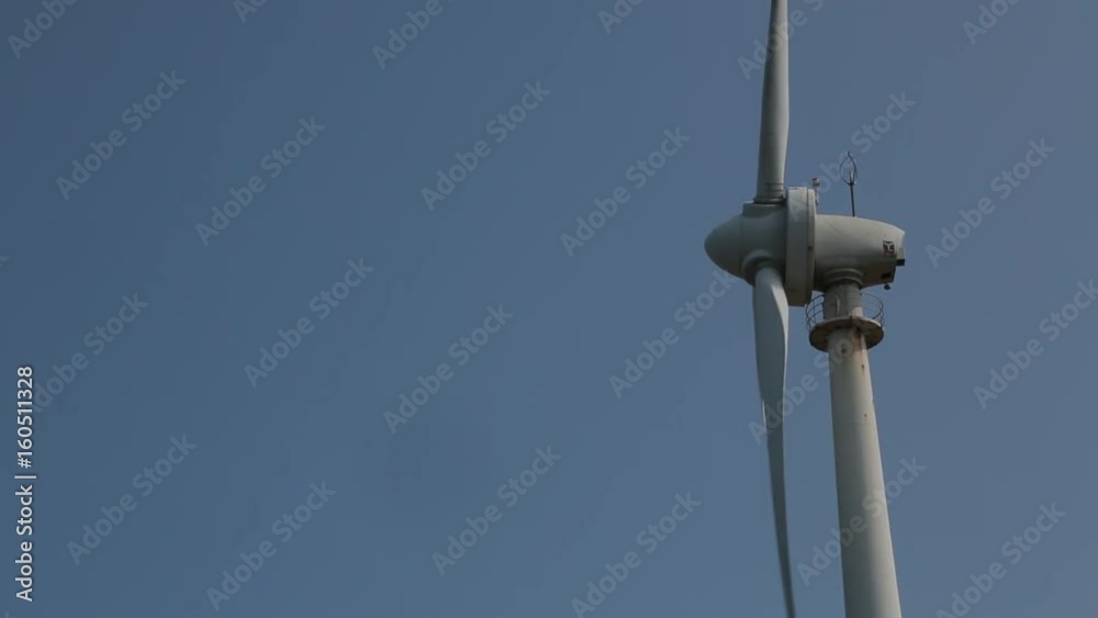Wind turbines are moving at a wind power station in Penghu Island, Taiwan. The sky is blue. Wind turbines are moving at a wind power station in Penghu Island, Taiwan. The sky is blue.