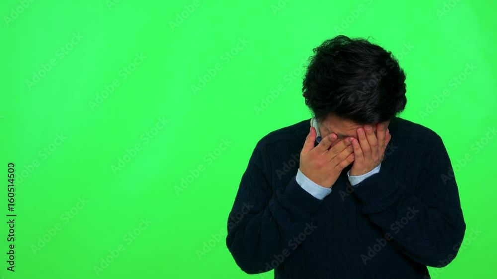 A young Asian man crying - green screen studio A young Asian man crying - green screen studio