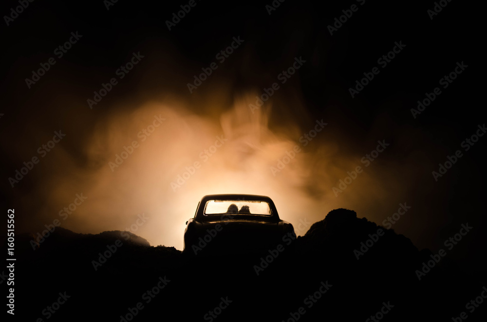 silhouette of car with couple inside on dark background with lights and smoke. Romantic scene. Love concept silhouette of car with couple inside on dark background with lights and smoke. Romantic scene. Love concept