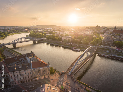 Aerial view at stunning sumer sunset, people walking through Bernatka bridge over Vistula river in Krakow, Poland.