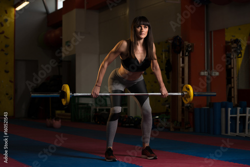 Woman Doing Exercise For Back With Barbell