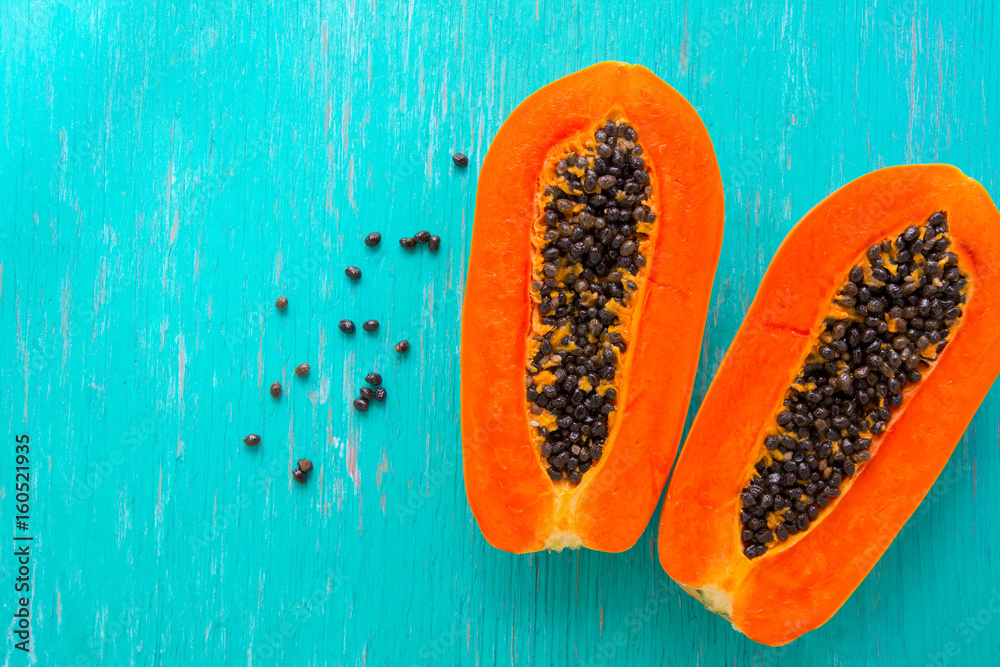 Papaya fruit on wooden background.Slices of sweet papaya on wooden background,Halved papayas with leaves, Papaya fruit on wooden background.Slices of sweet papaya on wooden background,Halved papayas with leaves,