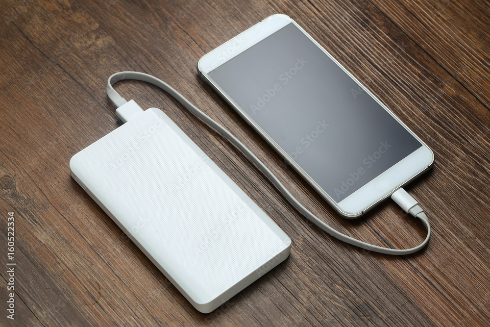 powerbank and cellphone on wooden table powerbank and cellphone on wooden table