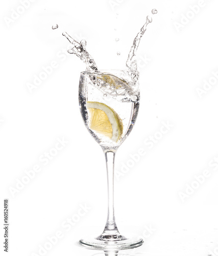 Lemon slice falls in a glass of water - Splash
