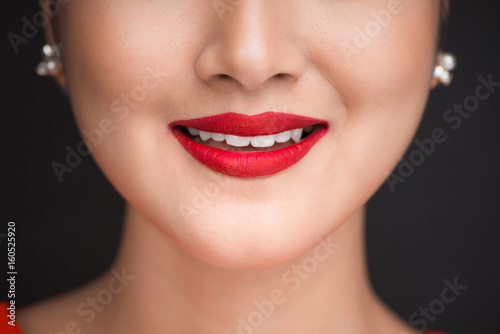 Beauty. Close up view of beautiful woman lips with red matt lipstick