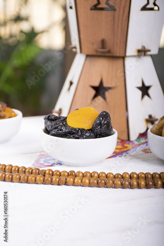 Ramadan Atmosphere - Collection of Ramadan Fruits and Nuts with Lantern on wooden table photo