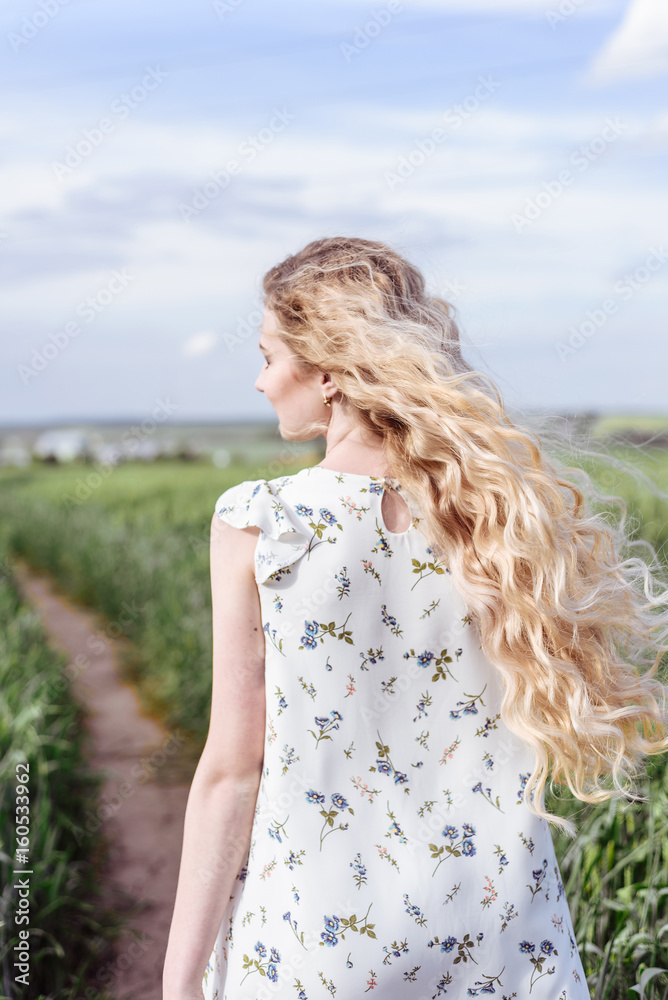 Summer portrait of beautiful blonde lady in wheat field