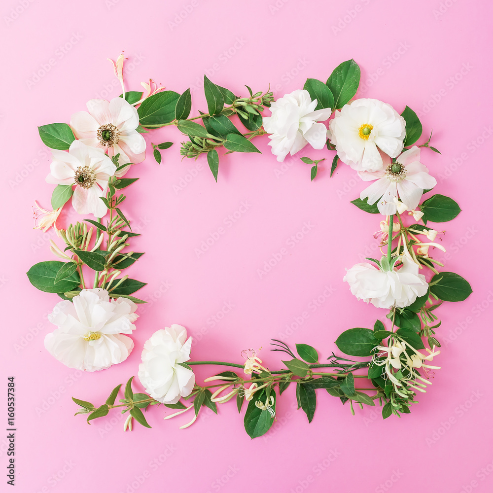 Floral frame made of white flowers and leaves on pink background. Floral background. Flat lay, top view. 