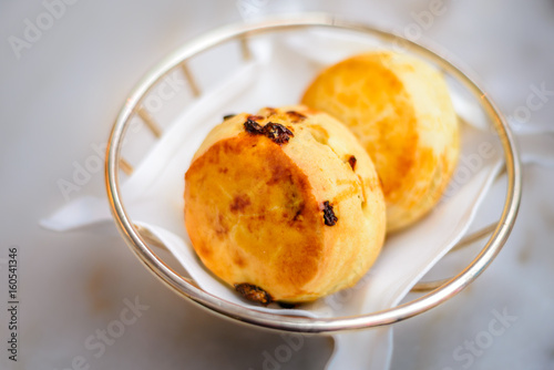 plain scone and raisin scone in basket with white linen photo