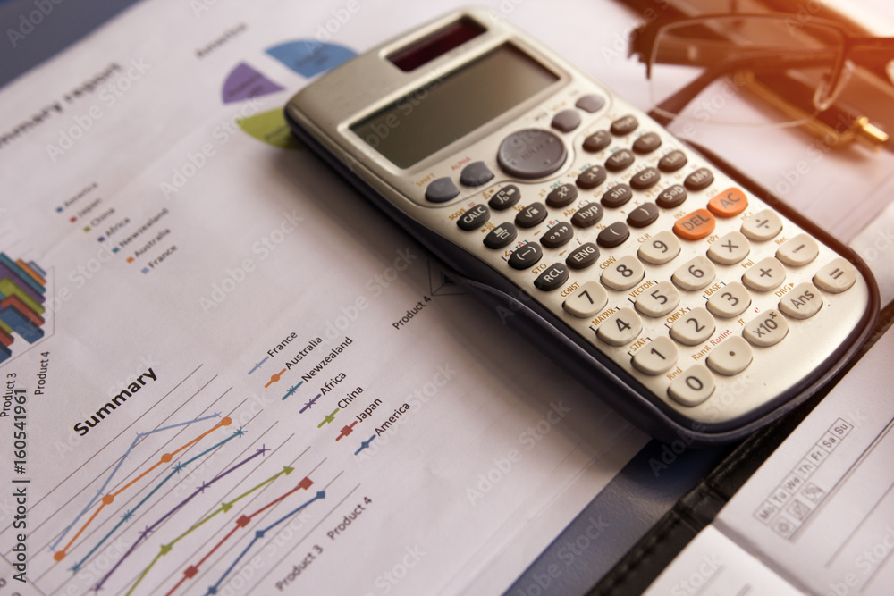 Calculator with business graphs and charts report on tabble, calculator on desk of financial planing. Financial abstract concepts. Calculator with business graphs and charts report on tabble, calculator on desk of financial planing. Financial abstract concepts.